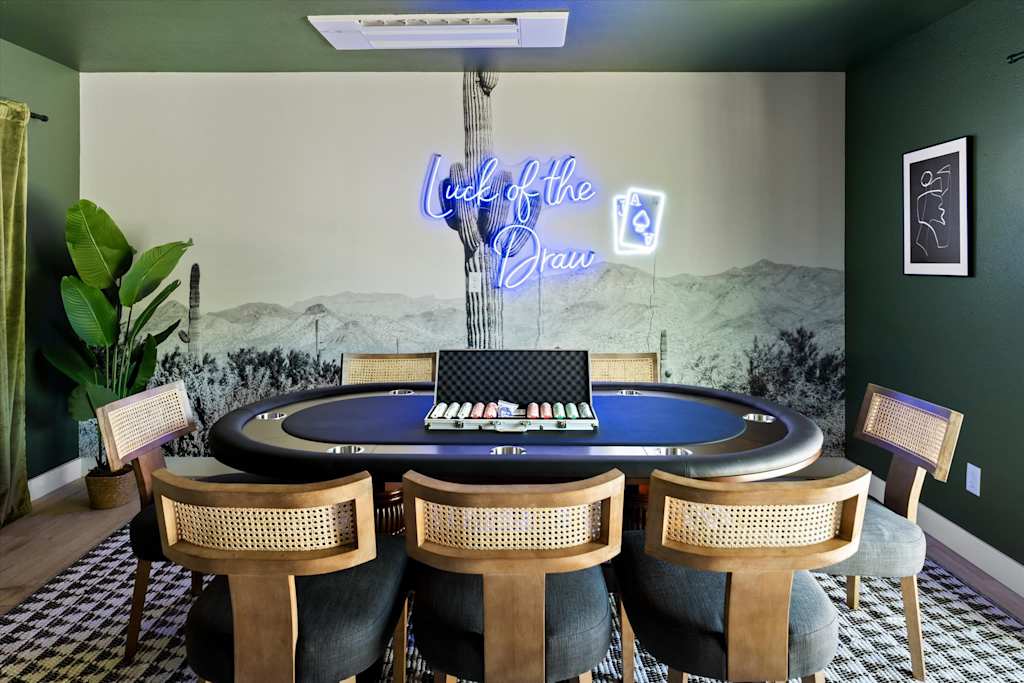 The Scottsdale Social — poker table with chairs and a chip set in front of a cactus wall mural
