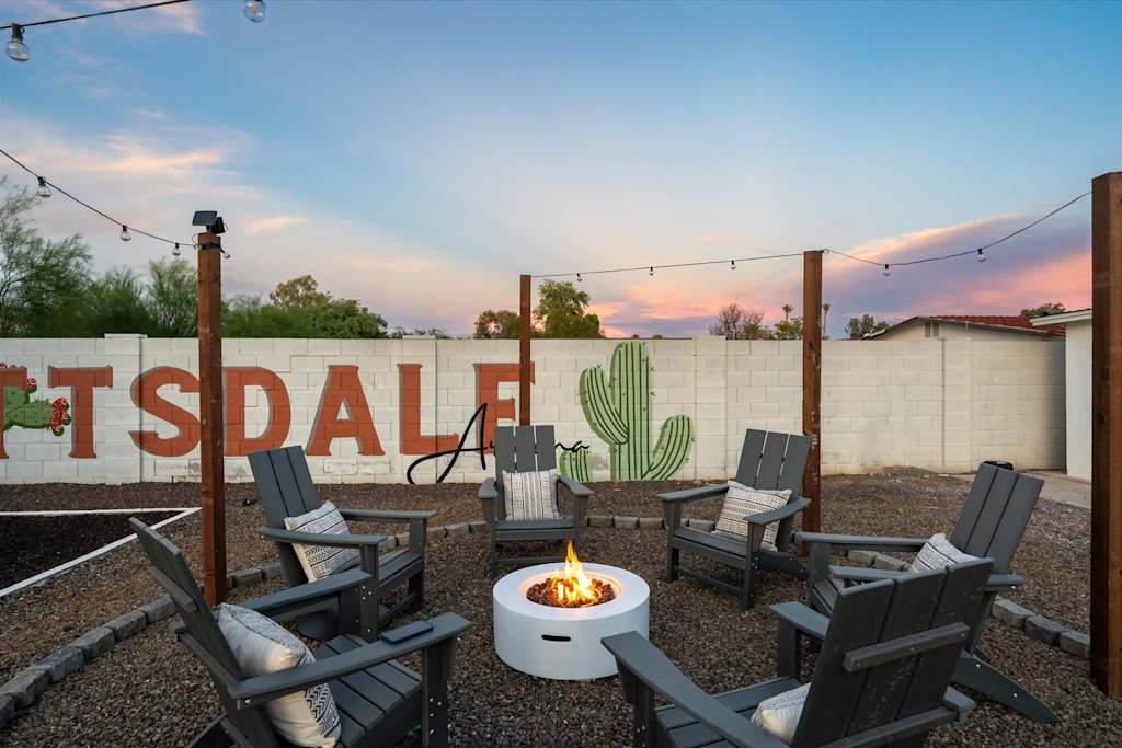 The Scottsdale Social — outdoor gravel patio featuring a circular fire pit surrounded by adirondack chairs under string lights