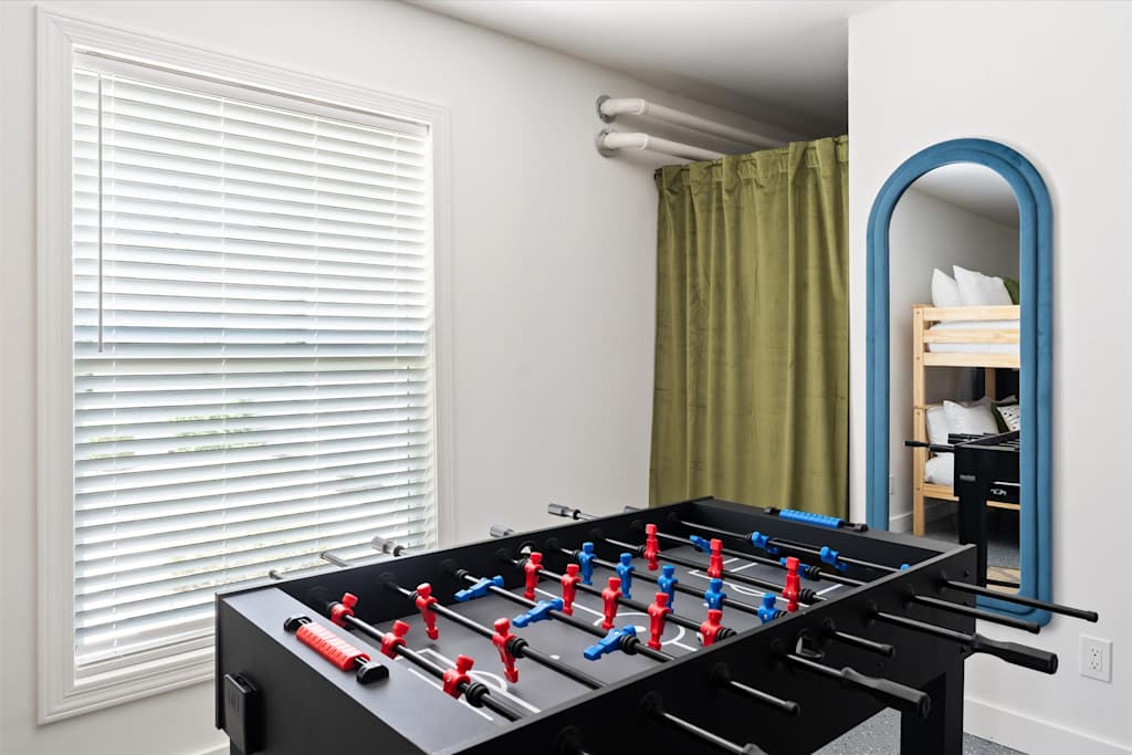 The Scottsdale Social — foosball table in a room with a large window and an arched mirror reflecting bunk beds