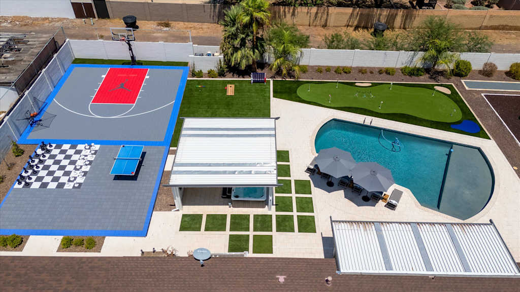 The Scottsdale Social — aerial top-down view of backyard with swimming pool, basketball half-court, putting green, and outdoor games