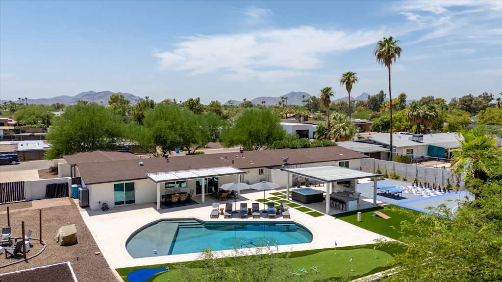 The Scottsdale Social — elevated view of vacation home backyard featuring a swimming pool, covered patios, and putting green