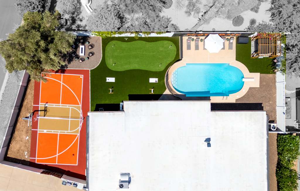 The Sunkiss — overhead aerial view of the backyard with swimming pool, sports court, and putting green