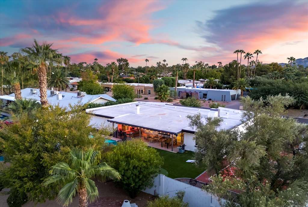 The Sunkiss — aerial view of the house and surrounding neighborhood under a colorful sunset sky