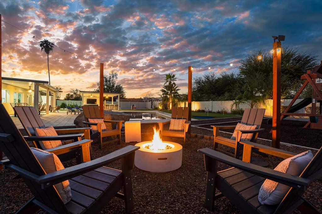 The Scottsdale Social — adirondack chairs surrounding a lit round fire pit in a gravel backyard at sunset