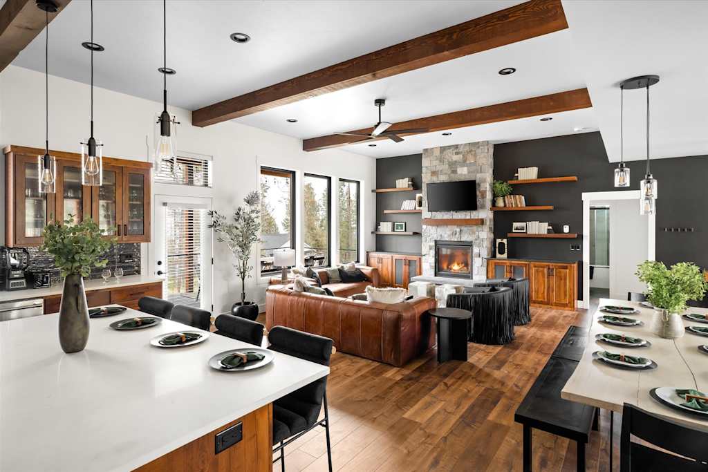 The Evergreen — open floor plan showing kitchen island foreground, living area with fireplace, and dining table