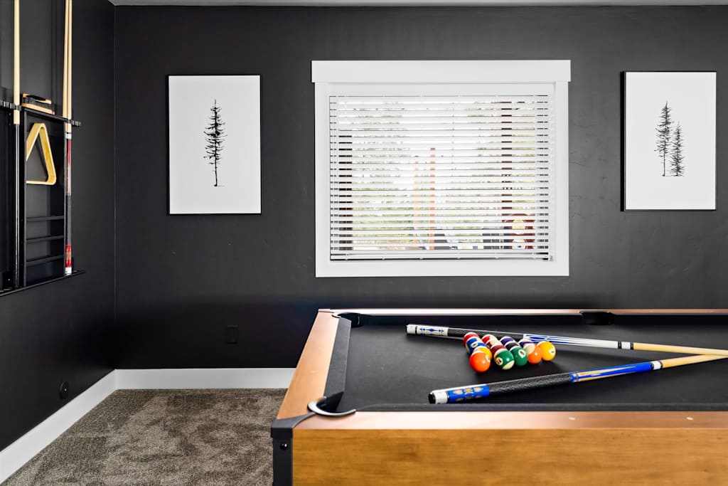 The Evergreen — close-up of a pool table with cues and billiard balls in a black-walled room