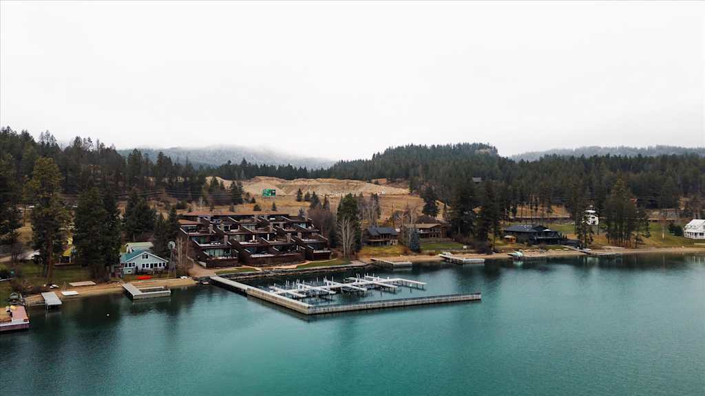 The Evergreen — aerial view of waterfront buildings, boat docks, and forest along a lake