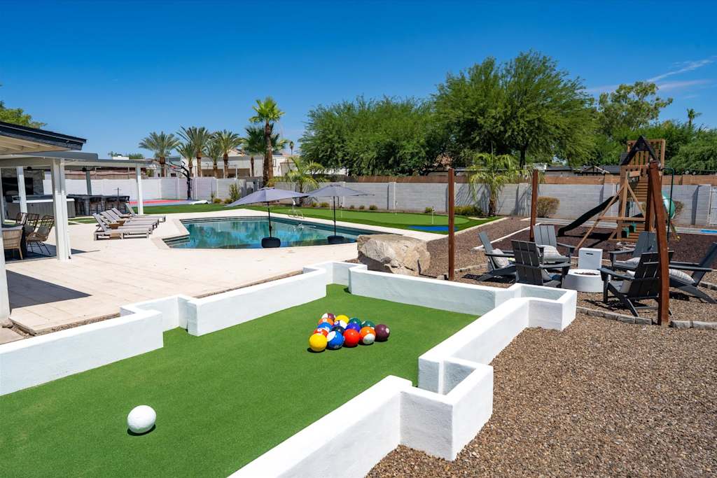 The Scottsdale Social — outdoor footpool game on turf in a backyard with a swimming pool and lounge chairs