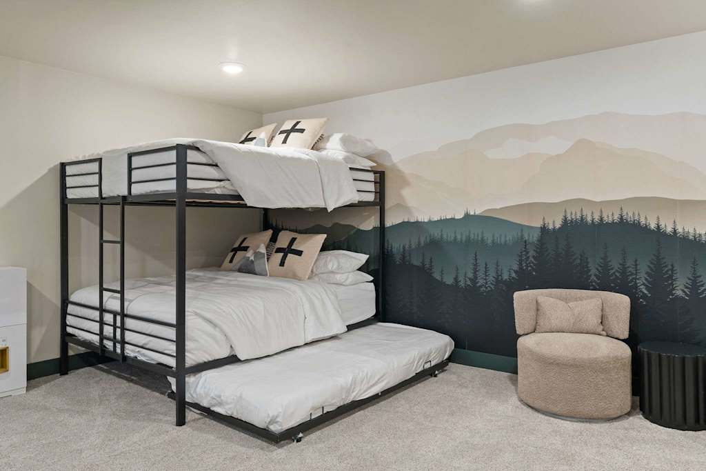 The Tamarack — metal bunk bed with a trundle bed against a mountain forest mural wall