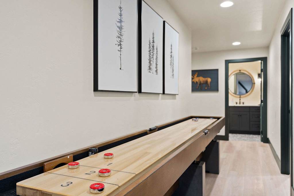 The Tamarack — wooden shuffleboard table lined up along an interior wall below framed artwork