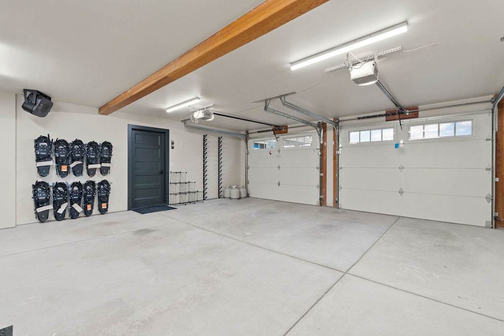 The Tamarack — spacious garage with snowshoes hanging on the wall and two overhead garage doors