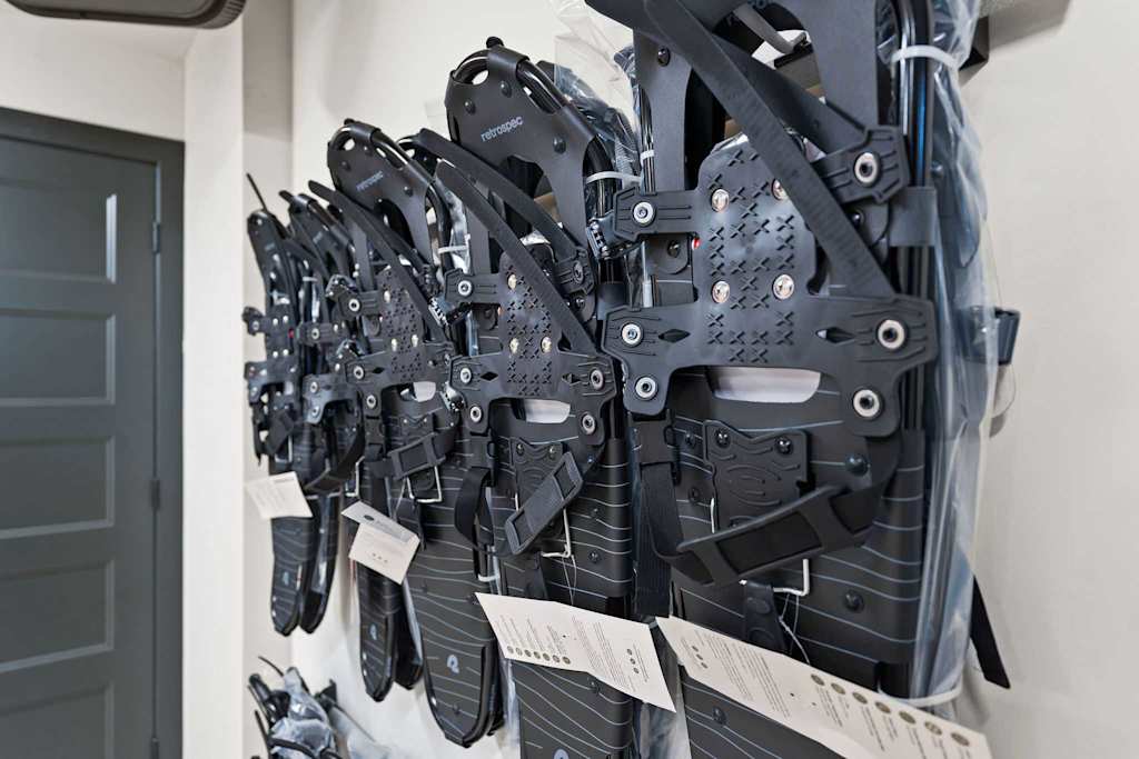 The Tamarack — close-up of black snowshoes mounted in rows on a wall