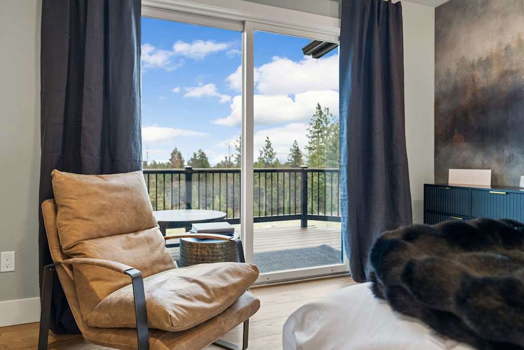 The Tamarack — leather armchair positioned in front of sliding glass doors leading to an outdoor deck