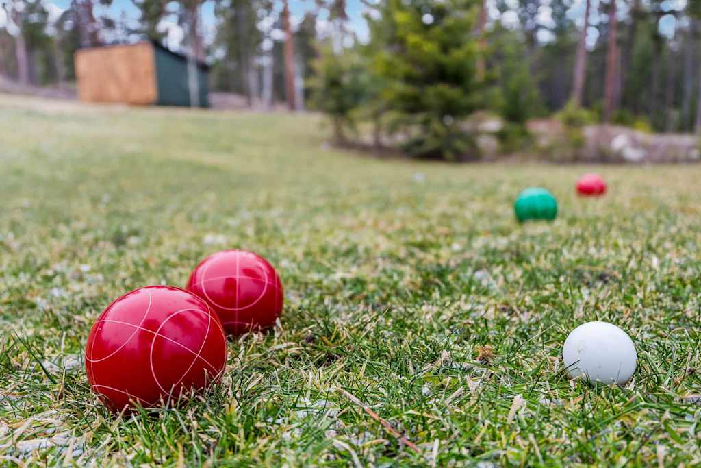 The Tamarack — close-up view of red, green, and white bocce balls on a grassy lawn