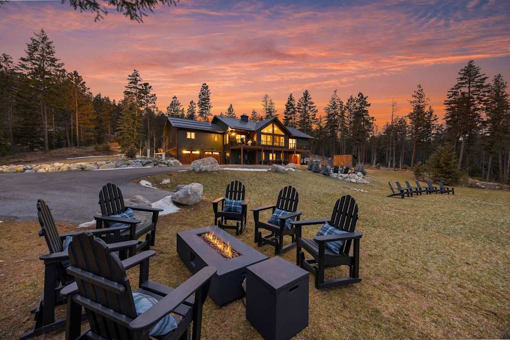 The Tamarack — lawn and outdoor fire pit table with chairs outside the lodge at sunset