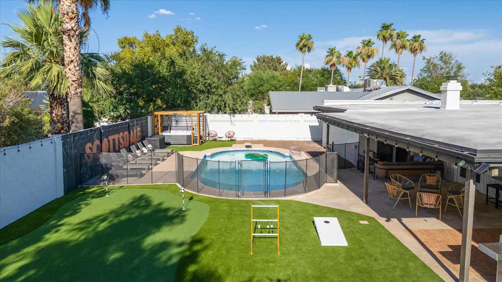 The Sunkiss — elevated view of backyard featuring fenced swimming pool, putting green, covered patio, and hot tub