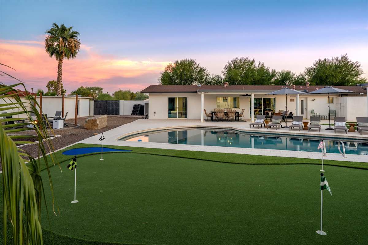 Wide daytime view of the pool, lawn and backyard amenities — The Scottsdale Social, Scottsdale, Arizona