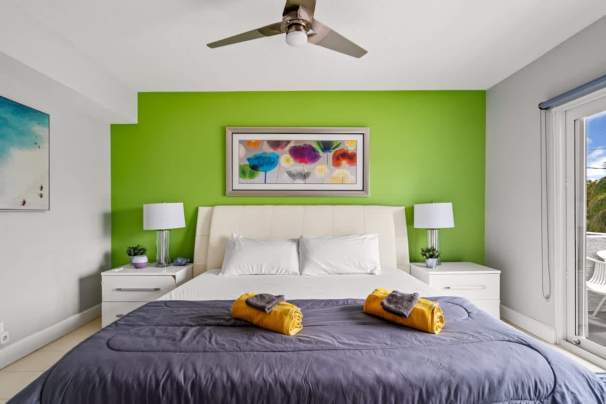 Pompano Condo: This bedroom has a bed, two nightstands and a door to the balcony