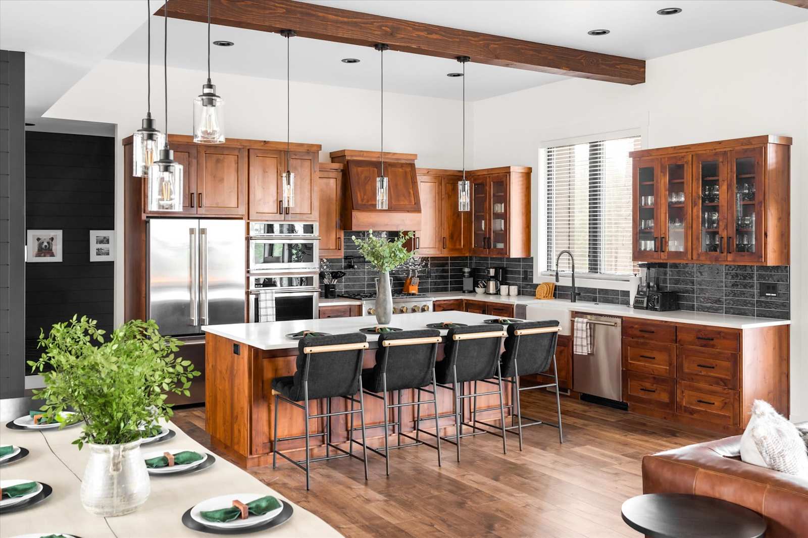Open kitchen with wood cabinets, pendant lights and seating at the island