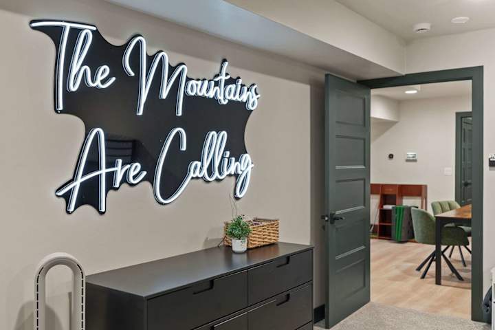 Hallway wall sign reading The Mountains Are Calling
