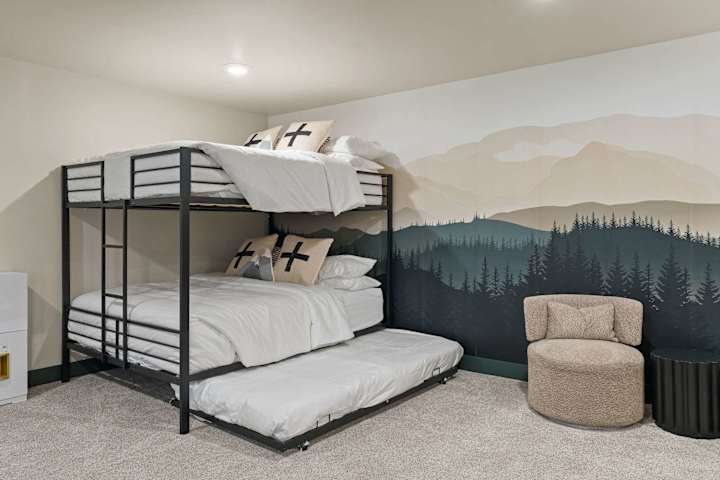 Bunk room with stacked beds and mountain mural