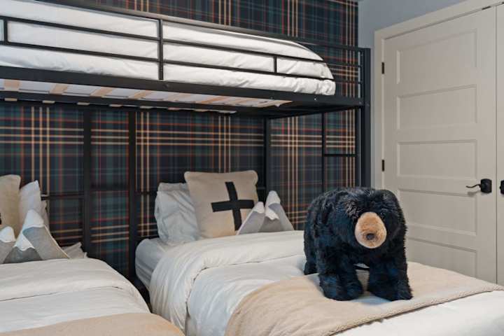 Bunk room with plaid wallpaper, teddy bear and stacked beds