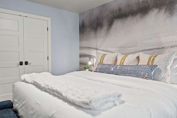 Bedroom with white bedding and mountain mural