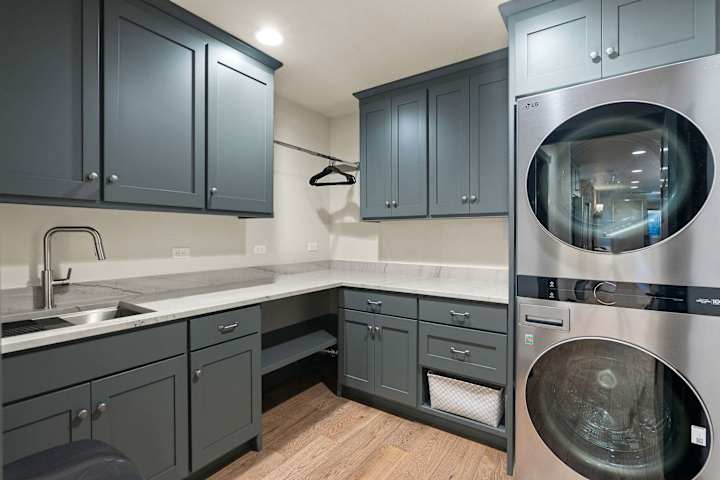 Laundry room with utility sink and stacked washer and dryer