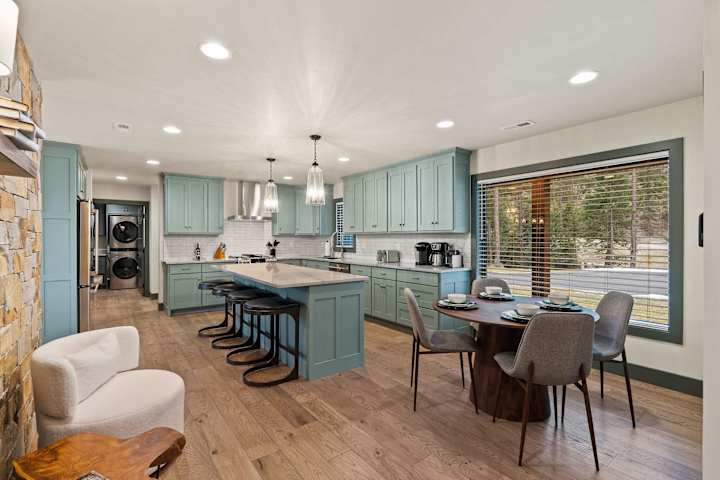 Open kitchen and dining space with pale green cabinetry