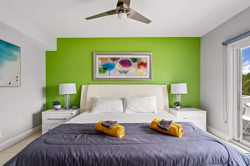 Pompano Condo: This bedroom has a bed, two nightstands and a door to the balcony