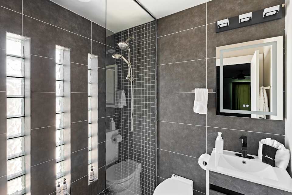 Bathroom vanity beside a tiled glass shower