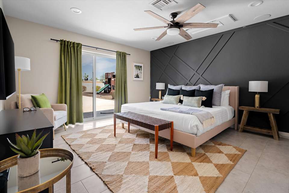 Bedroom with upholstered bed, bench and television
