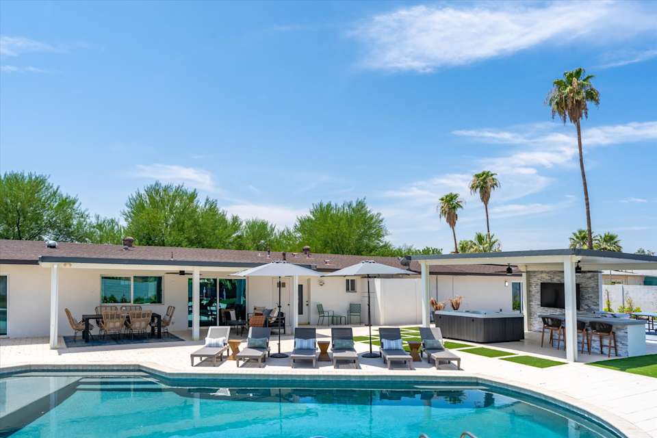 Wide pool view with loungers, lawn and shaded patios