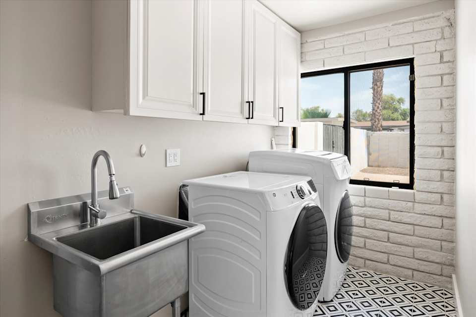 Laundry room with washer, dryer, sink and storage