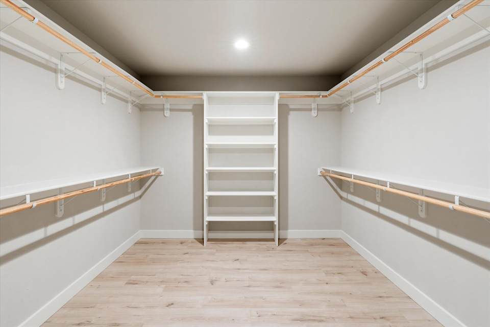 Walk-in closet with open shelving and hanging space