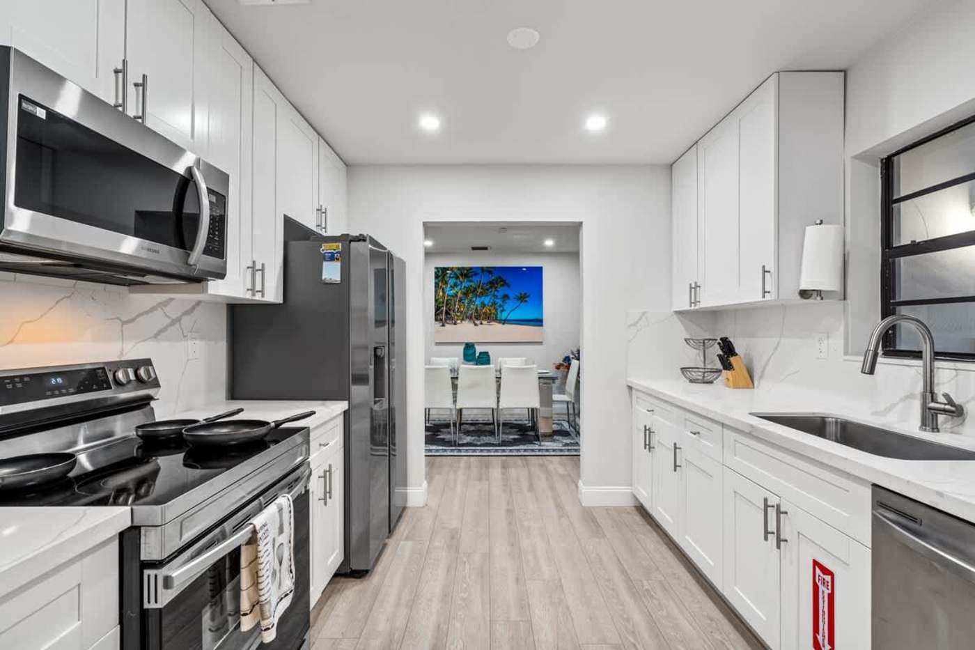 Gardens By The Sea: Galley kitchen with electric range and microwave, breakfast bar beyond