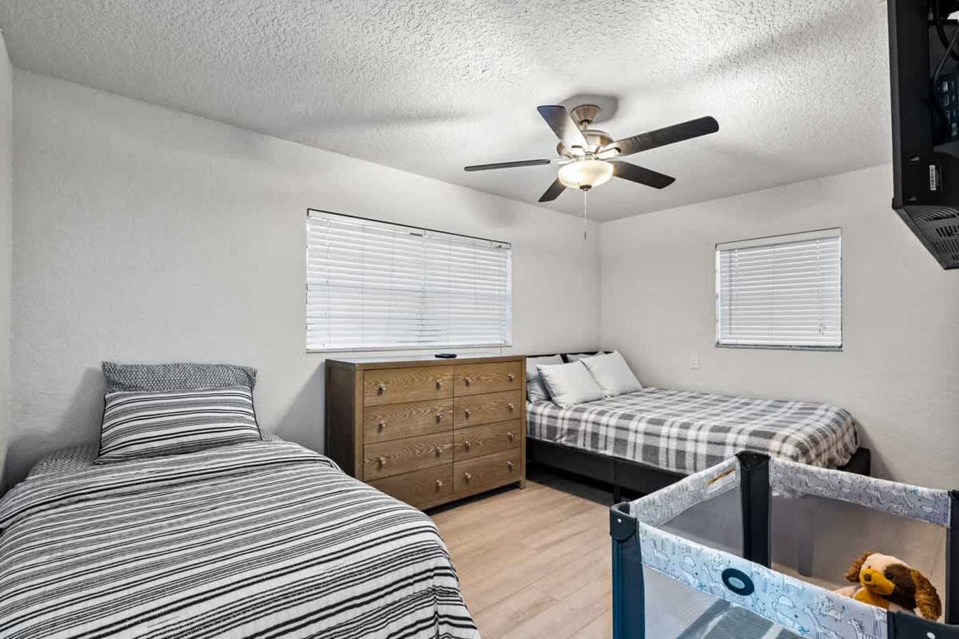 Gardens By The Sea: Twin room with two single beds, dresser and a travel cot
