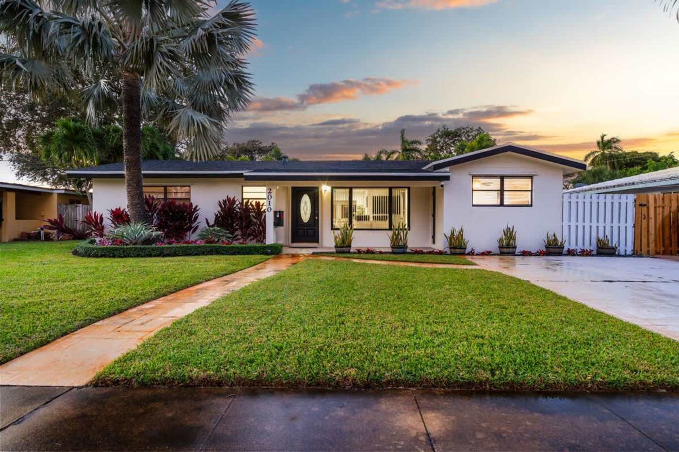 Gardens By The Sea: The house from the street at sunset, with the lawn and drive