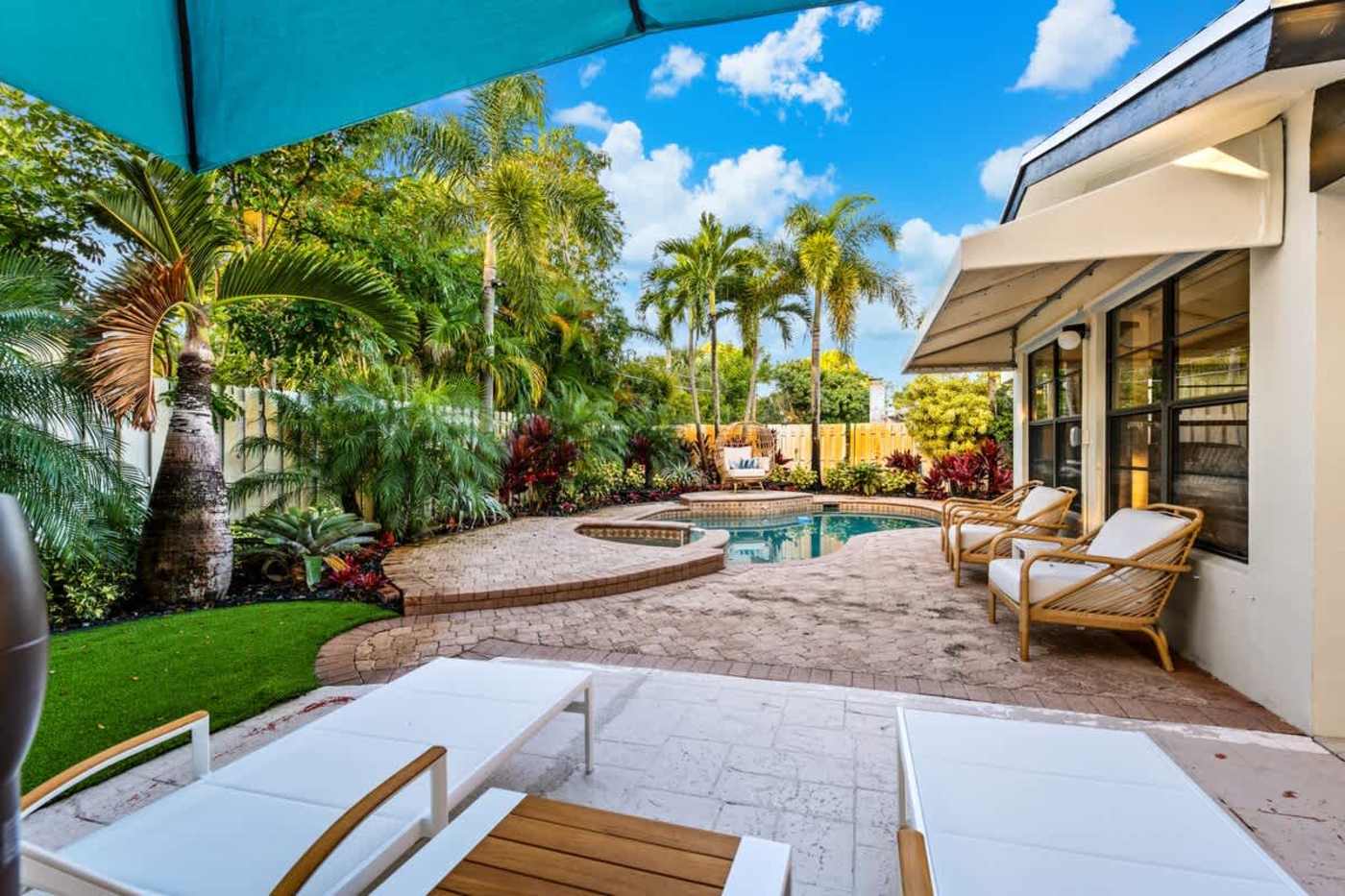 Gardens By The Sea: Sun loungers beside the pool, with the house and garden beyond