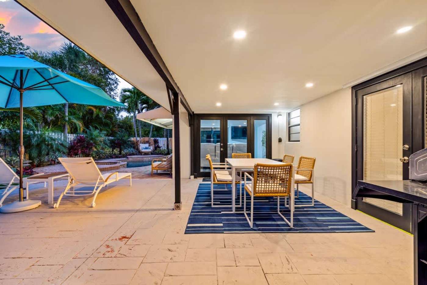 Gardens By The Sea: Covered patio with outdoor dining, rug and loungers by the pool