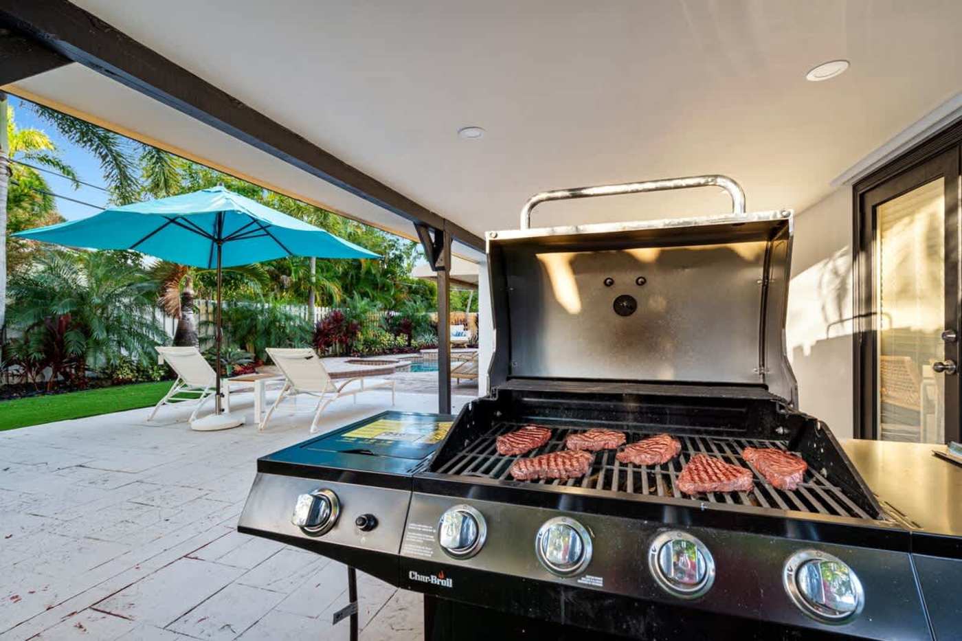Gardens By The Sea: Gas grill on the covered patio, with the pool beyond