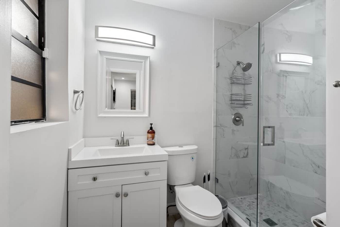 Gardens By The Sea: Bathroom with vanity, mirror and a glass walk in shower
