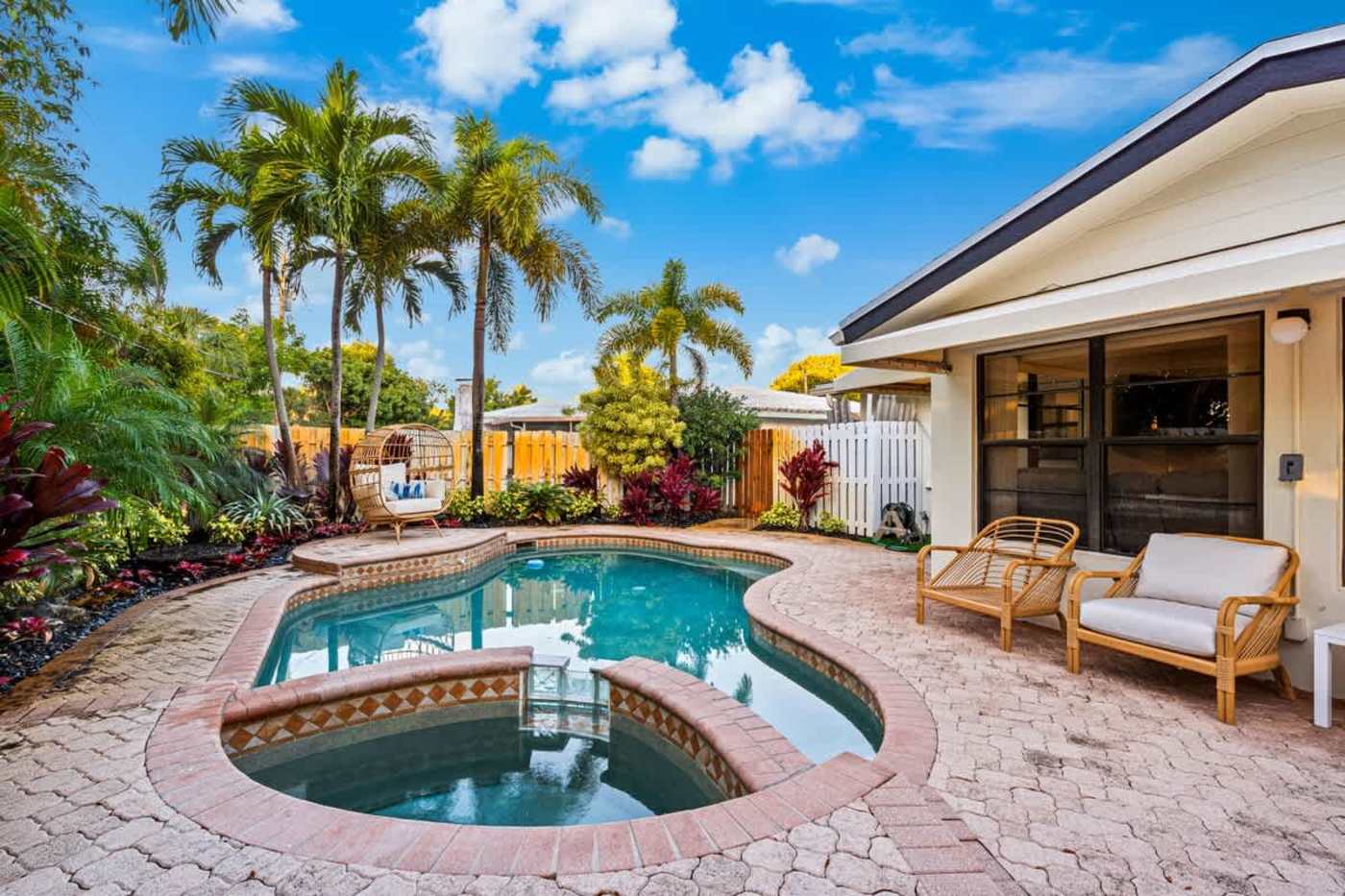 Gardens By The Sea: Heated pool and spa on the paver deck, with patio seating behind