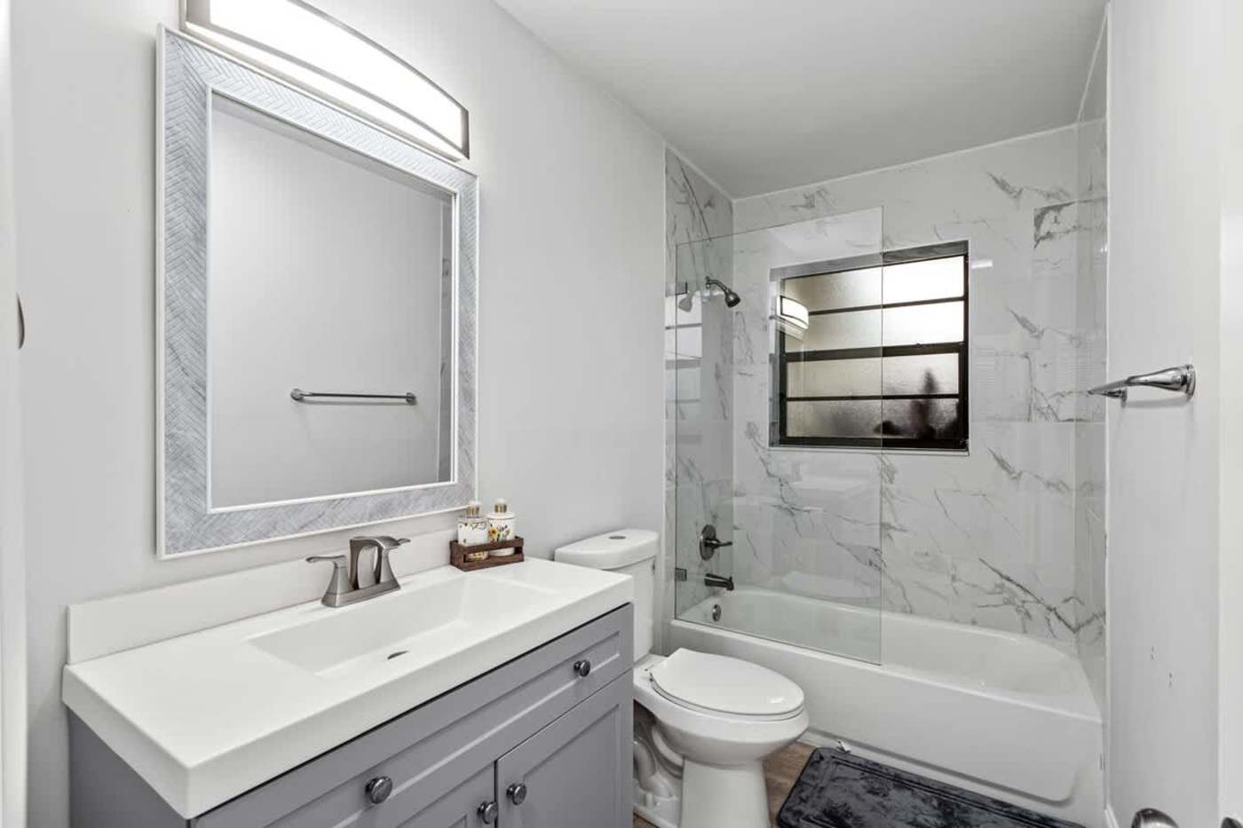 Gardens By The Sea: Bathroom with vanity, mirror and bath with shower over