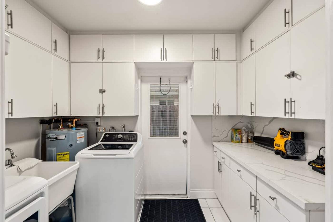 Gardens By The Sea: Utility room with washer, dryer and storage cupboards