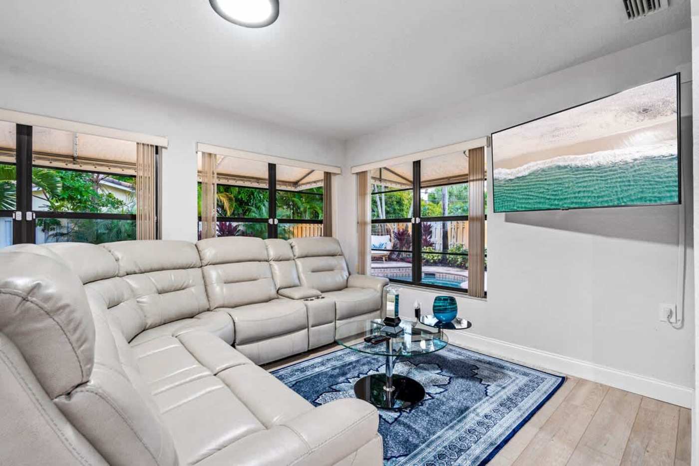 Gardens By The Sea: Living room with reclining sectional and a wall mounted TV