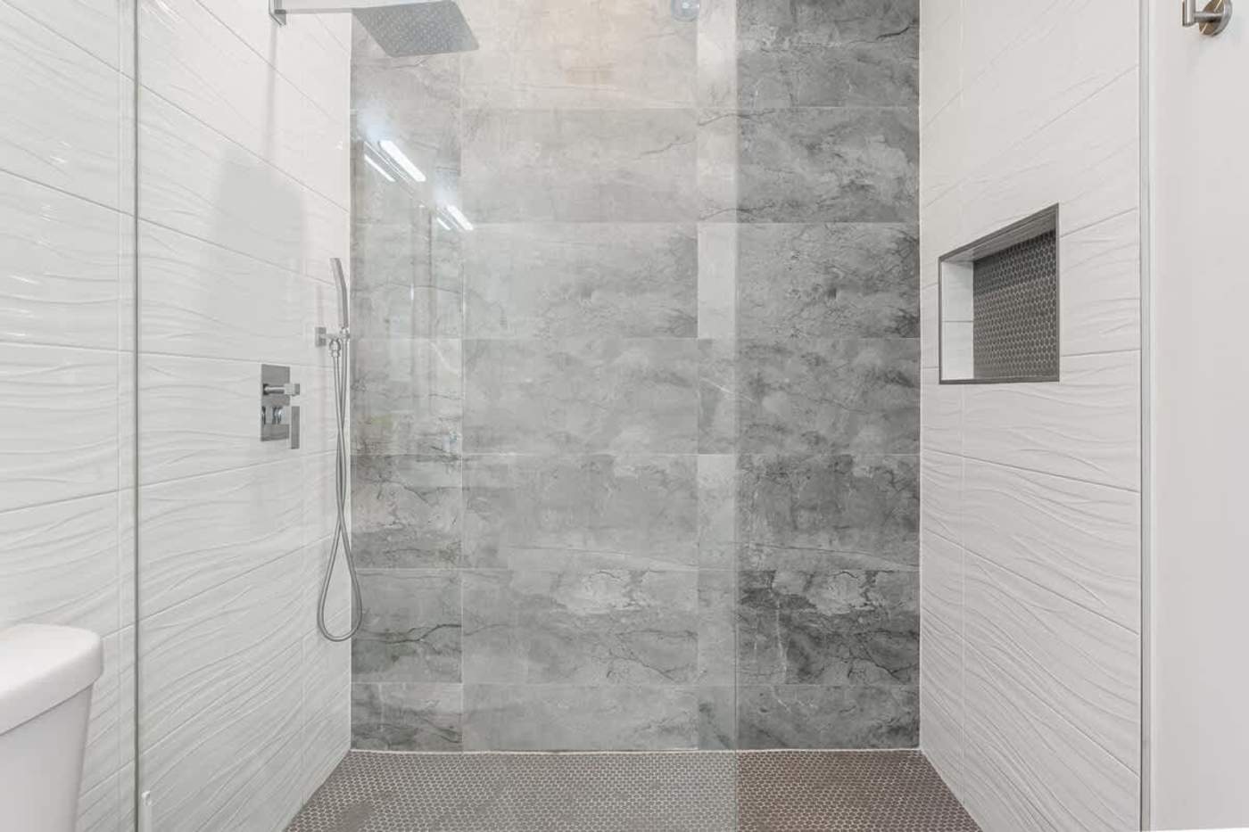 The Arcade House: Walk in shower with tiled walls and a recessed shelf