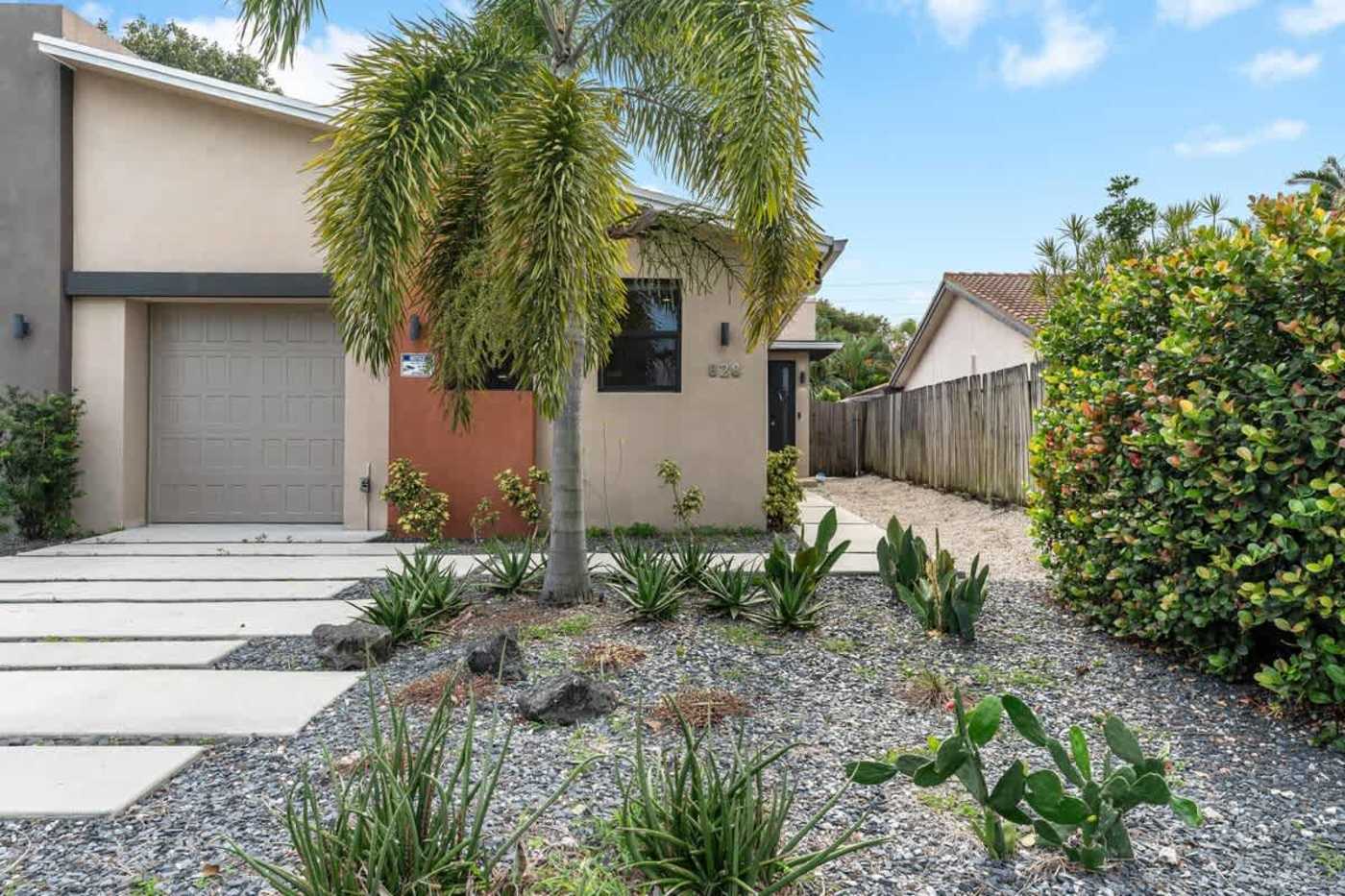 The Arcade House: Front garden with palms, gravel planting and a stepping stone path
