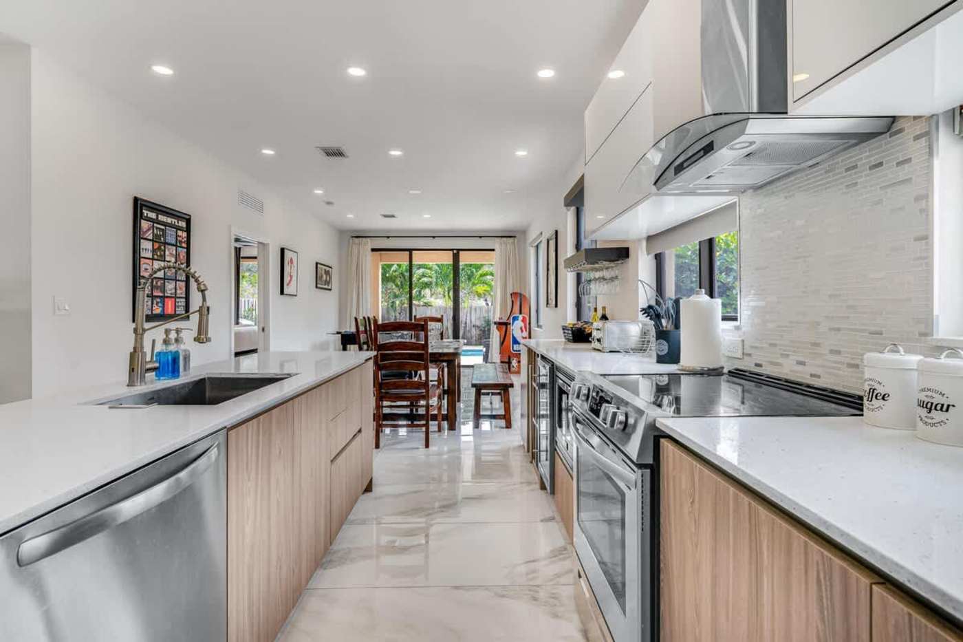 The Arcade House: Galley kitchen with dishwasher, oven and range hood, open to the dining area