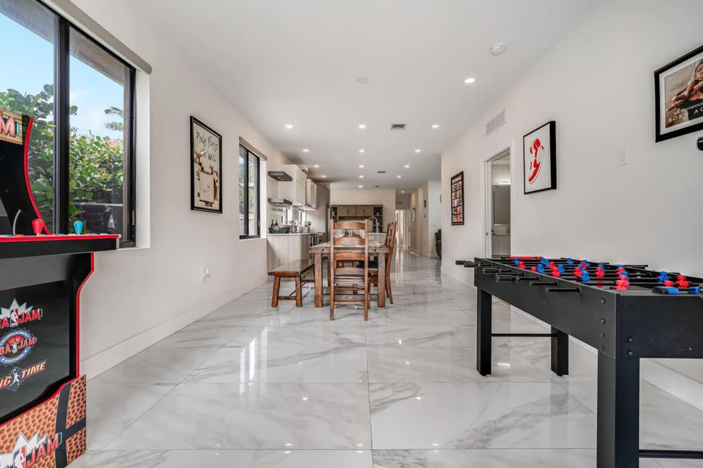 The Arcade House: Games area with arcade machine and foosball, looking to the dining room